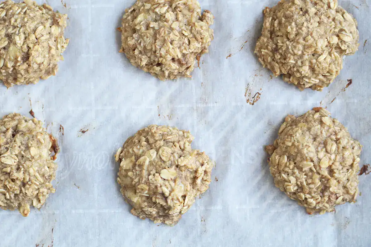 Baked banana cookies on a parchment-lined baking sheet.
