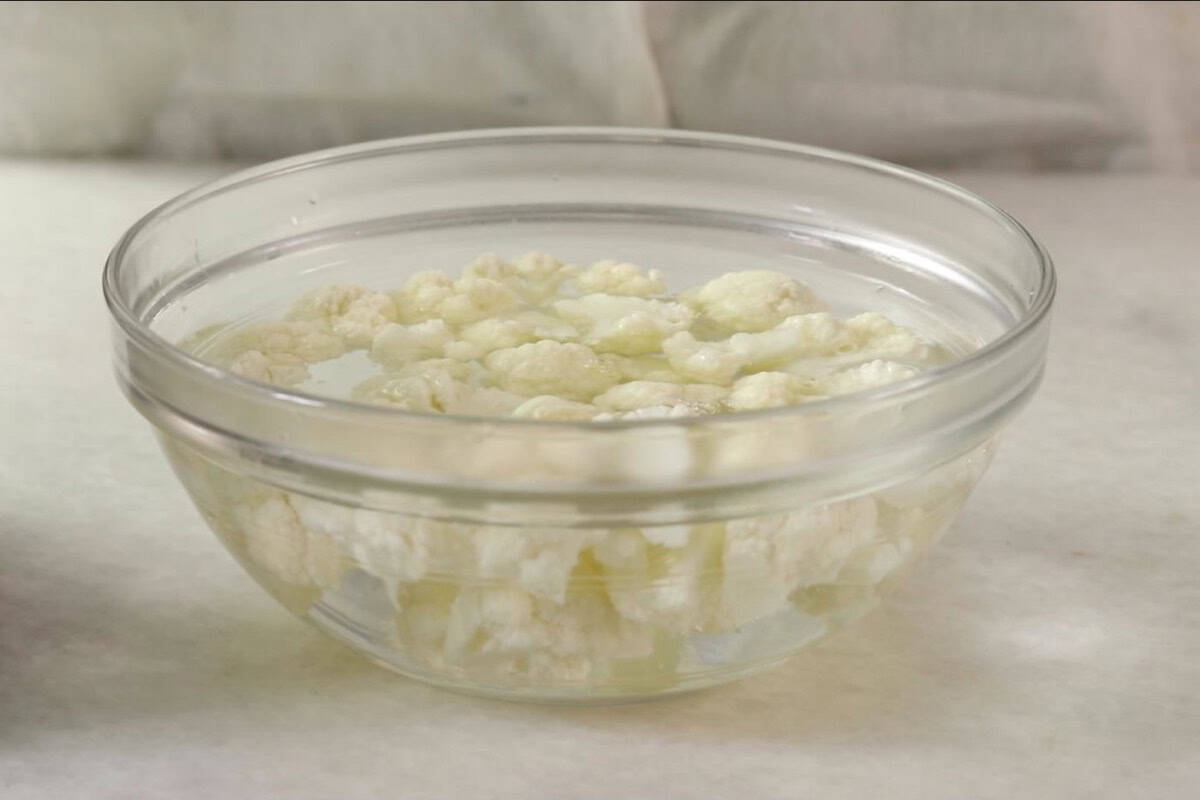 Cauliflower florets soaking in water for cauliflower tots.