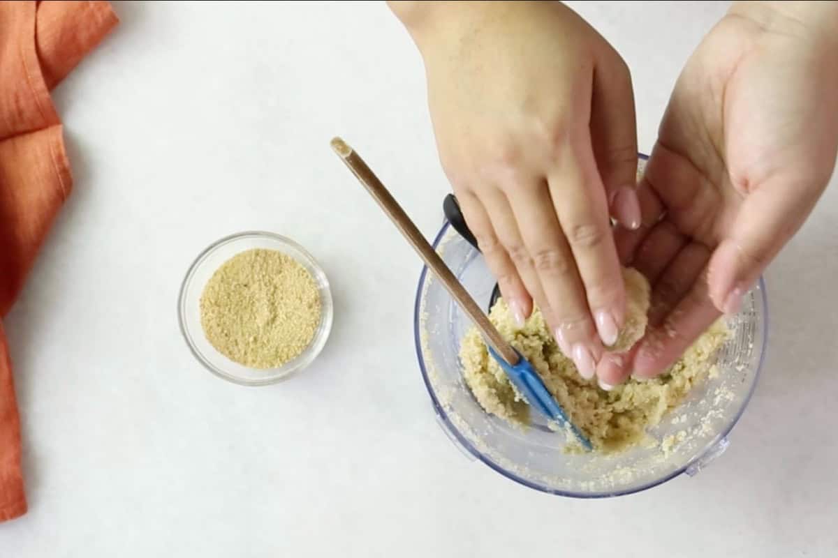 Hands shaping the cauliflower mixture into tots.