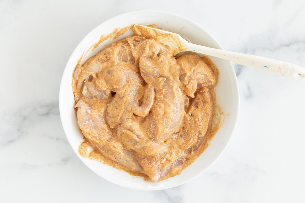 Chicken tenderloins coated in yogurt marinade.
