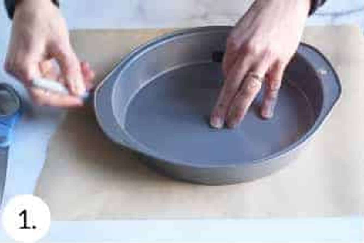 Round cake pan being traced onto parchment paper.