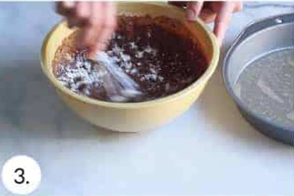 Chocolate football cake batter mixed in a yellow bowl.