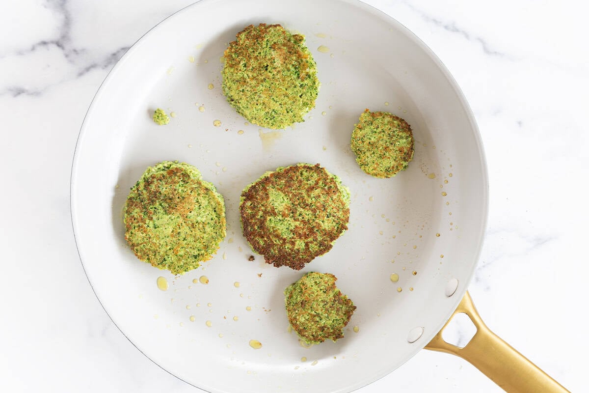 Cooked broccoli fritters in a skillet.