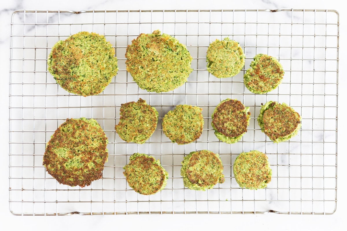 Cooked broccoli fritters on a cooling rack.