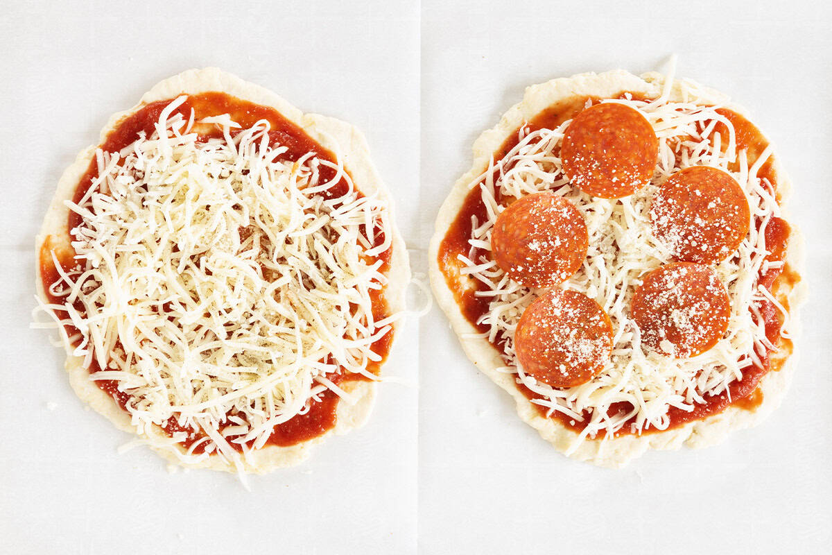 Two pizzas topped with cheese and pepperoni.