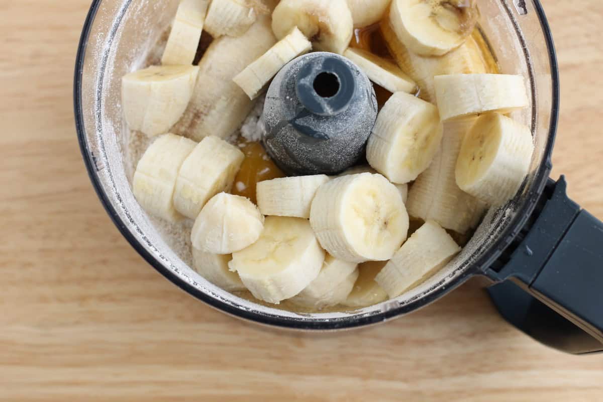 Bananas and other cake ingredients in a food processor.