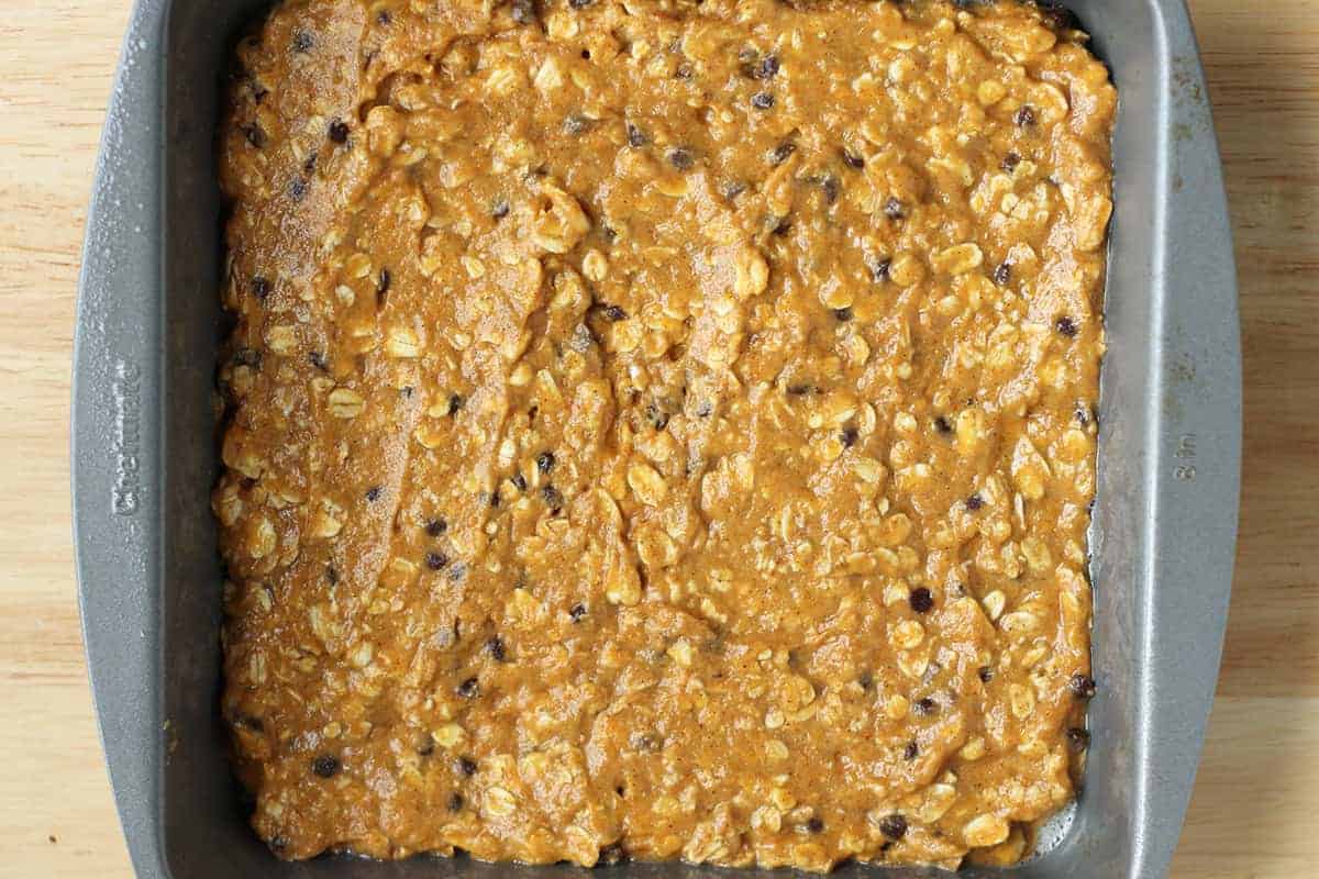 Pumpkin bar batter spread in a square baking pan.