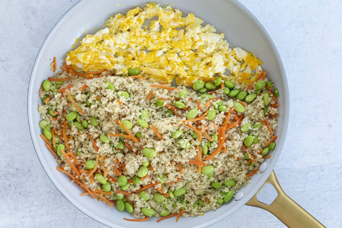 Quinoa fried rice with scrambled eggs in a skillet.