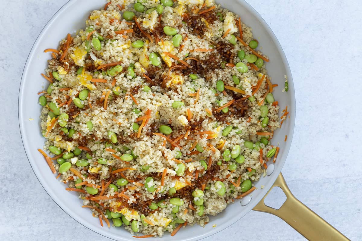 Quinoa fried rice with sauce in a skillet.