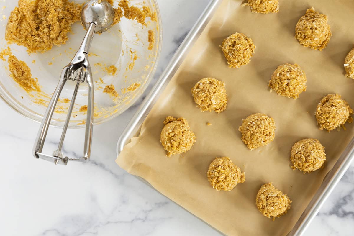 Flattened sweet potato cookies on a baking sheet.