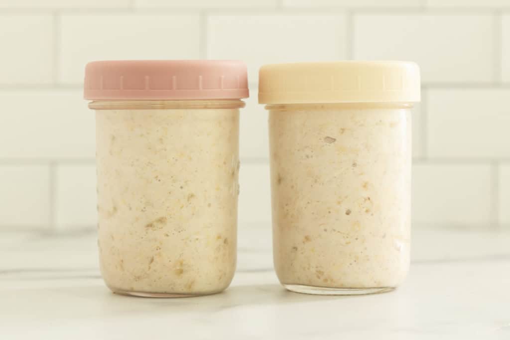 Banana overnight oats stored in two lidded glass jars.