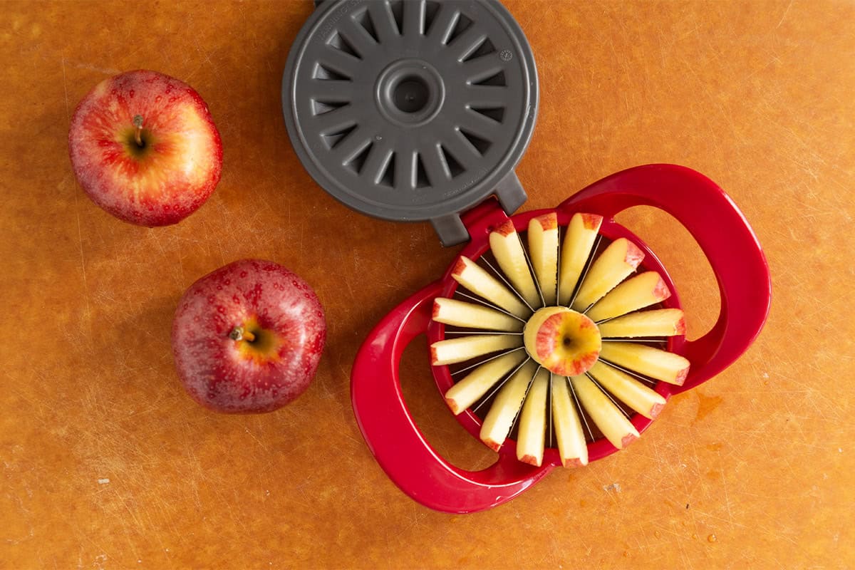 Apple wedges cut with an apple slicer on a cutting board.