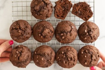 Chocolate pumpkin muffins on a cooling rack, including one split open.