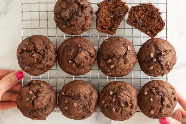 Chocolate pumpkin muffins on a cooling rack, including one split open.