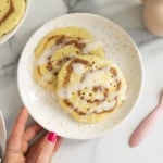 Cinnamon swirl pancakes on plate with strawberries on side.