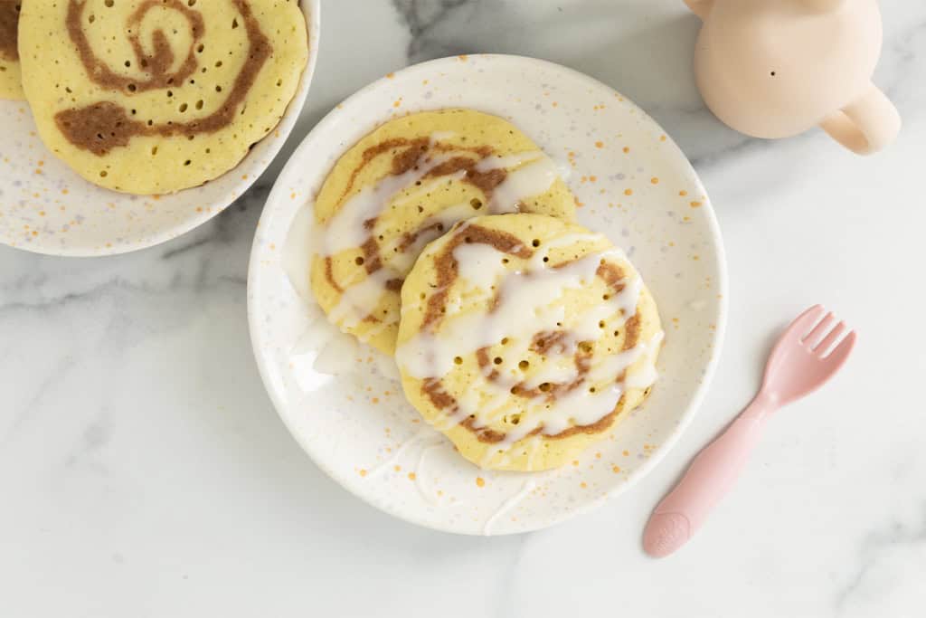 Cinnamon swirl pancakes on plate with pink fork.