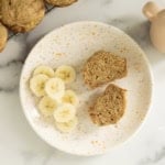 Egg free banana muffins on plate with banana slices.