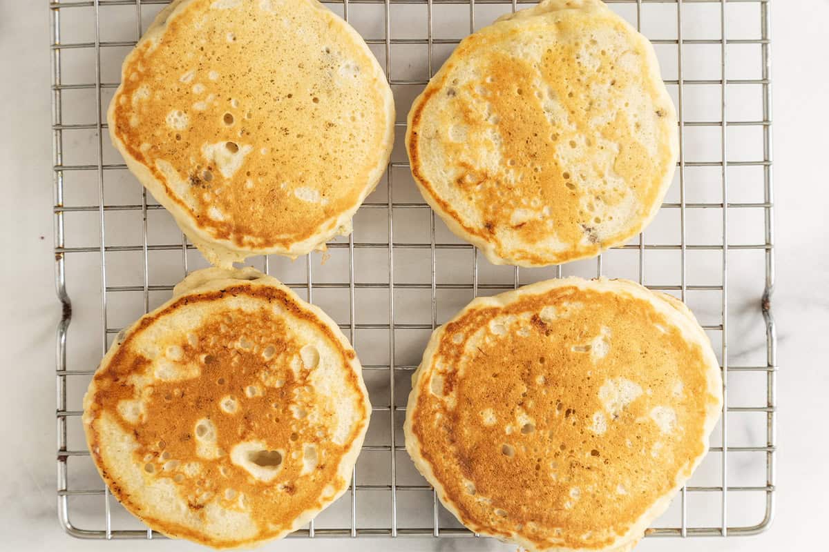 Eggless banana pancakes cooling on a wire rack.