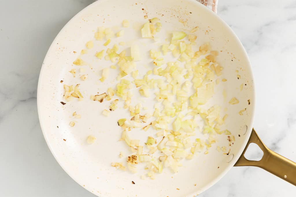Onions in pan for lemon orzo chicken.