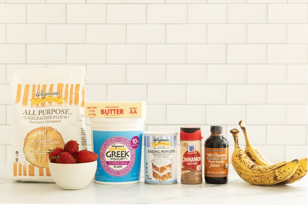 Ingredients for strawberry banana pancakes arranged on a countertop.