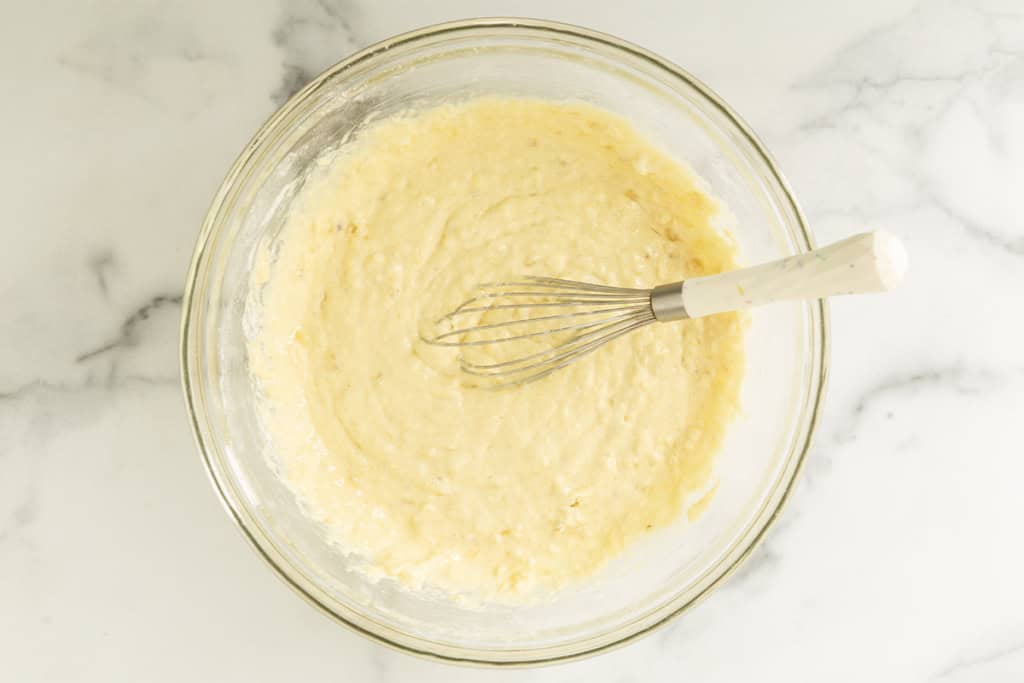 Strawberry banana pancake batter mixed in a glass bowl.