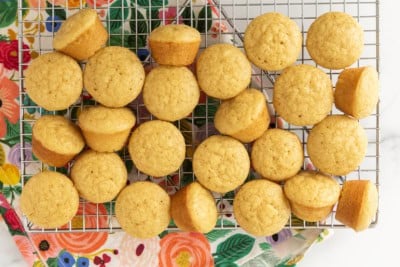 Mini vanilla muffins cooling on a wire rack.